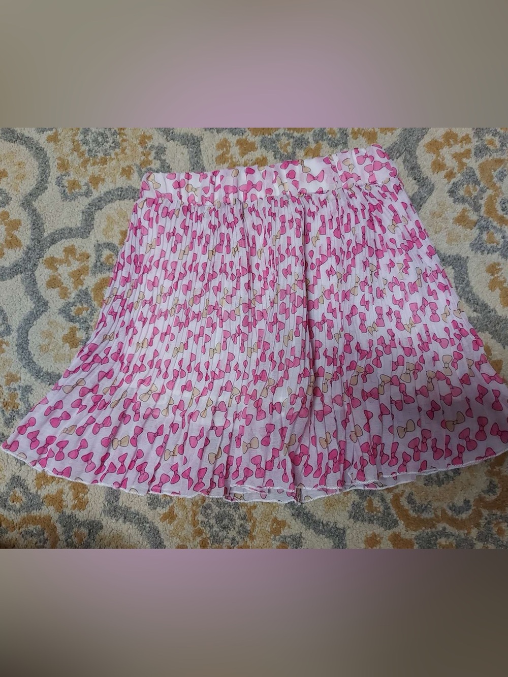 Pink pleated mini skirt with bow tie print